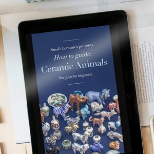 Peut inclure: Une tablette numérique affichant un guide pour débutants sur la façon de réaliser des animaux en céramique. Le guide est intitulé "Small Ceramics présente Comment guider : Animaux en céramique. Le guide pour débutants". L'image montre une variété d'animaux en céramique colorés, notamment des zèbres, des éléphants et des chats.