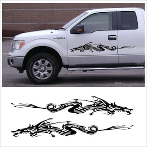 May include: Black dragon car decals. The decals are shown on a white truck. The dragon design is a stylized, tribal-inspired illustration. The dragon's body curves along the side of the vehicle, with a long, flowing tail.
