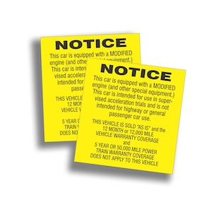 May include: Two yellow warning stickers with black text. The text reads "NOTICE This car is equipped with a MODIFIED engine (and other special equipment.) This car is intended for use in supervised acceleration trials and is not intended for highway or general passenger car use. THIS VEHICLE IS SOLD "AS IS" and the 12 MONTH or 12,000 MILE VEHICLE WARRANTY COVERAGE and 5 YEAR OR 50,000 MILE POWER TRAIN WARRANTY COVERAGE DOES NOT APPLY TO THIS VEHICLE."