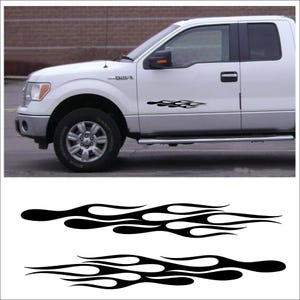 May include: Black flame decals for a white pickup truck. The decals are a stylized flame design, suitable for application on the side of a vehicle. The image also shows the decals on a white truck.