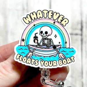 May include: A white badge holder with a skeleton in a boat with a rainbow and the text "Whatever Floats Your Boat".