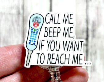 May include: White badge holder with a blue and white cartoon image of a medical device with the text "CALL ME, BEEP ME, IF YOU WANT TO REACH ME..."