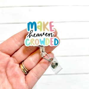 May include: A colorful badge holder with the text "Make heaven crowded" in a rainbow font. The badge holder is attached to a clear retractable badge reel.