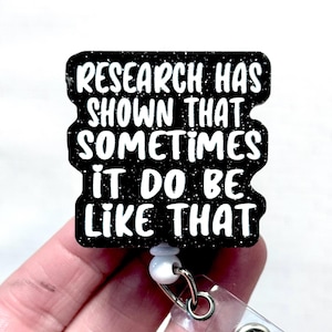May include: Black and white badge reel with the text "RESEARCH HAS SHOWN THAT SOMETIMES IT DO BE LIKE THAT". The badge reel has a glittery finish and a clear plastic strap with a metal clip.