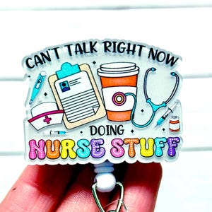 May include: A white ceramic mug with a black handle and the text "But First, Coffee" in a black, bold font. The mug is on a white surface.