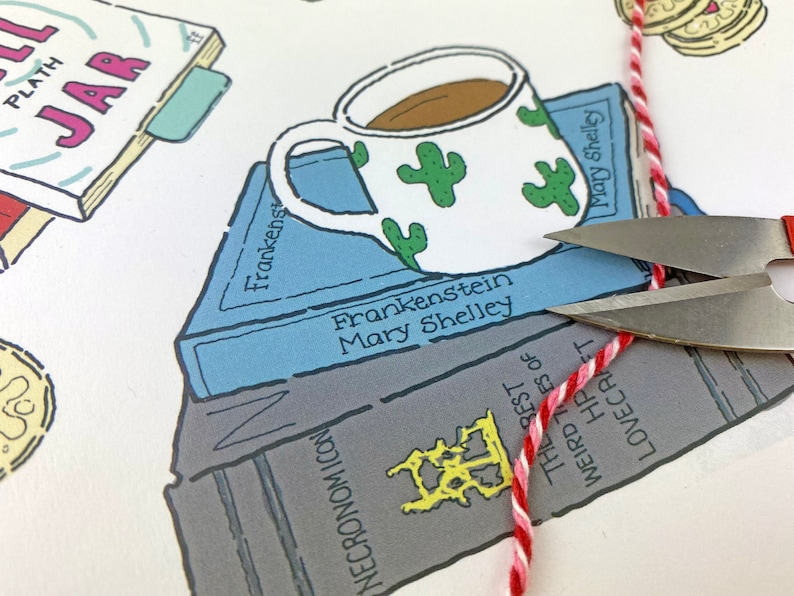 May include: A white coffee mug with green cactus designs sits on top of a stack of books. The books are titled "Frankenstein" by Mary Shelley and "The Rest of Weird Tales of HP Lovecraft". A red and white string is being cut with scissors.