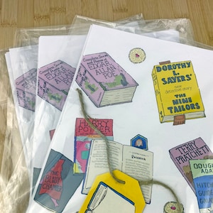 May include: A white sheet of paper with various book covers printed on it. The covers include titles like "Complete Stories and Poems of Edgar Allan Poe", "Harry Potter and the Philosopher's Stone", "The Bloody Chamber", "Dorothy L. Sayers' The Nine Tailors", "Terry Pratchett", and "Douglas Adams' The Hitchhiker's Guide to the Galaxy".