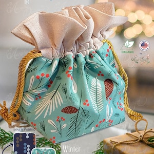 May include: A reusable cotton gift bag with a winter pinecone design. The bag is made of 100% GOTS organic cotton and has a drawstring closure. The bag is perfect for gifts or for storing small items.