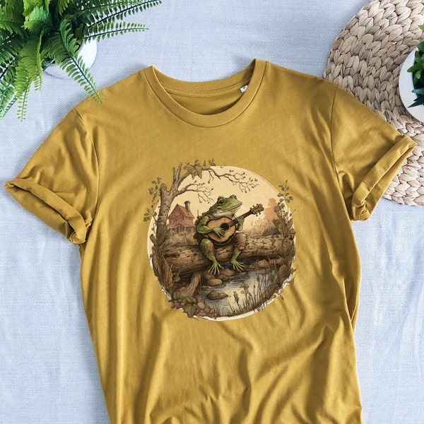 Cottagecore Aesthetic Frog che suona uno strumento su una camicia di tronchi, T-shirt organica, unisex, rana, abbigliamento Cottage core, rana e rospo, nucleo fatato