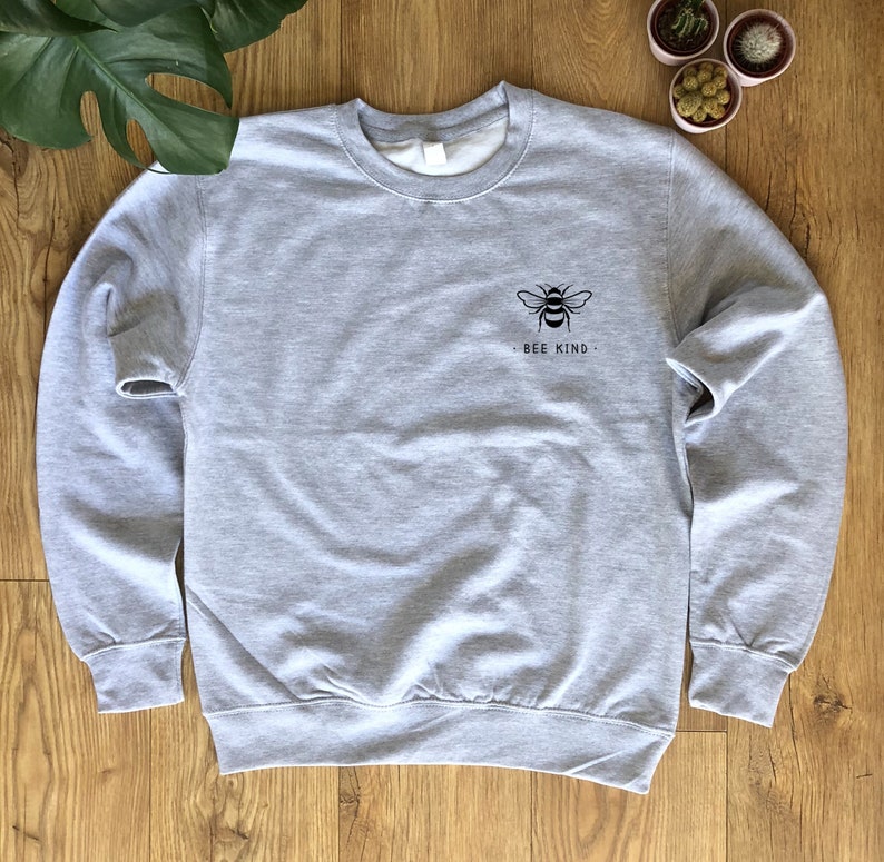 May include: A gray sweatshirt with a black bee graphic and the text "Bee Kind" on the front.