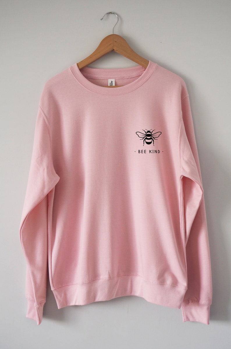 May include: A pink sweatshirt with a black bee graphic and the text "BEE KIND" on the front.