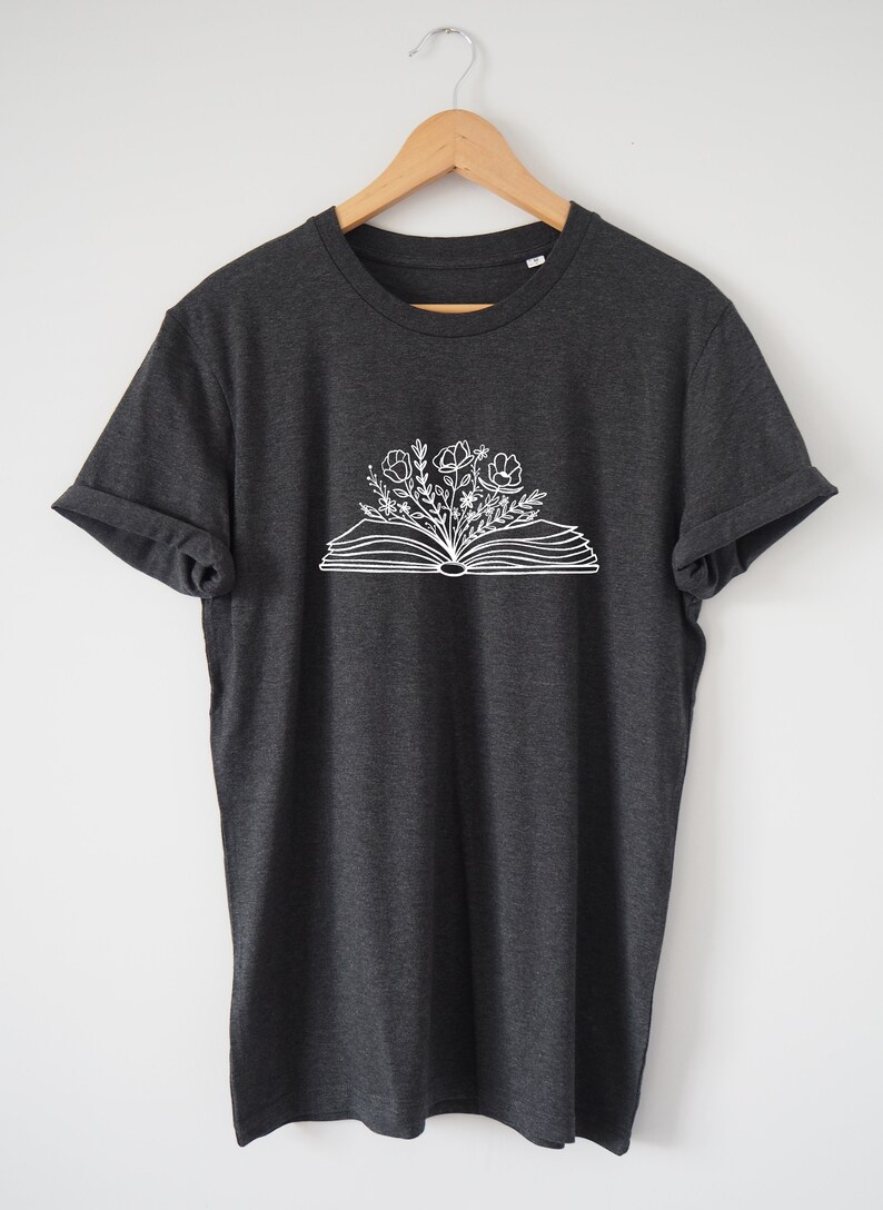 May include: A dark heather grey t-shirt with a white graphic of an open book with flowers growing from it.