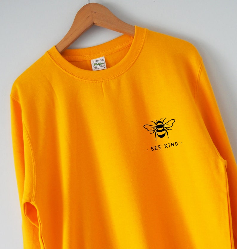 May include: A yellow sweatshirt with a black bee graphic and the text "BEE KIND." printed on the front.