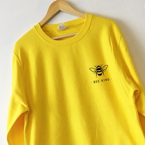 May include: Yellow sweatshirt with a black bee graphic and the text "BEE KIND."