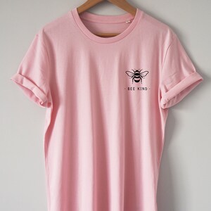 May include: A pink t-shirt with a black bee graphic and the text "Bee Kind" on the front.