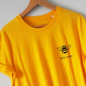 May include: A yellow t-shirt with a black bee graphic and the text "BEE KIND."