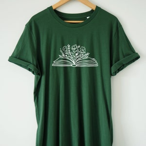 May include: A dark green t-shirt with a white graphic of an open book with flowers growing out of it.