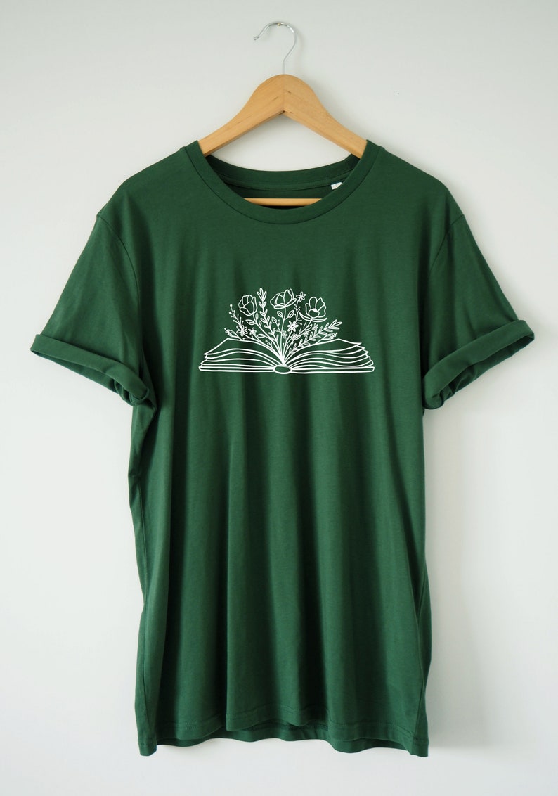 May include: A dark green t-shirt with a white graphic of an open book with flowers growing out of it.