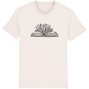 May include: A white t-shirt with a black line drawing of an open book with flowers growing out of it.