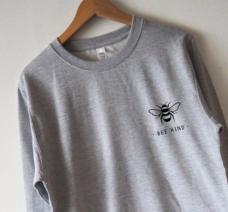 May include: A gray sweatshirt with a black bee graphic and the text "BEE KIND" on the front.