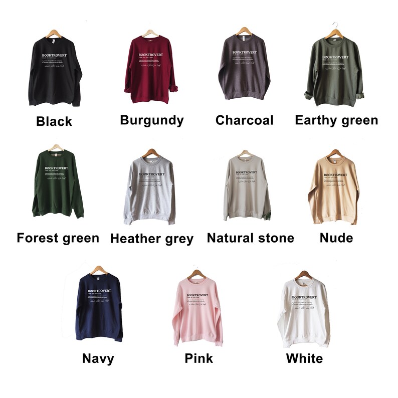 May include: Twelve crewneck sweatshirts in various colors, including black, burgundy, charcoal, earthy green, forest green, heather grey, natural stone, nude, navy, pink, and white. Each sweatshirt features the text "BOOKTROVERT" printed on the front.