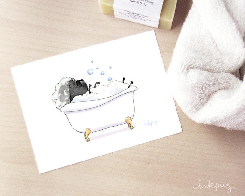 May include: A black pug dog is taking a bath in a white bathtub with bubbles. The pug is lying on its back with its paws in the air. The bathtub has gold feet.