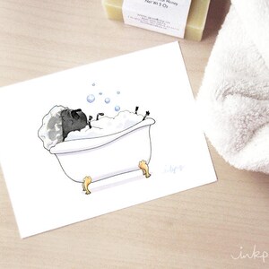 May include: A black pug dog is taking a bath in a white bathtub with bubbles. The pug is lying on its back with its paws in the air. The bathtub has gold feet.
