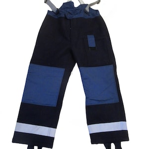 May include: Navy blue work pants with blue reinforced knee patches and reflective stripes at the ankles. The pants have suspenders and a small pocket. The work pants are designed for safety and visibility.