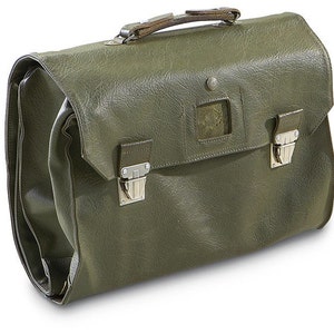 May include: Olive green leather briefcase with a top handle and two silver-tone metal clasps. The bag has a textured surface and a small, square emblem on the front. The briefcase is designed for carrying documents and other items.
