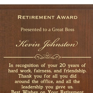 Op de afbeelding: Een bruine houten plaquette met gouden letters. De plaquette luidt "Retirement Award" en wordt gepresenteerd aan Kevin Johnston. De plaquette erkent 20 jaar hard werken, eerlijkheid en vriendschap. Het bevat ook een boodschap van dank en beste wensen voor zijn pensioen van de medewerkers van Kelver Plastics in Chicago, IL op 12 mei 2020.