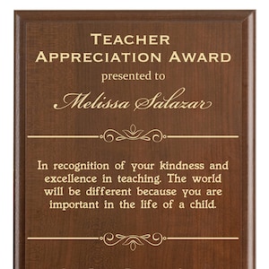 May include: A brown wooden plaque with gold lettering that reads "Teacher Appreciation Award" presented to "Melissa Salazar". The plaque includes a message of appreciation for the teacher's kindness and excellence in teaching. The plaque is from Jason Roberts Elementary School in Wakefield, GA.