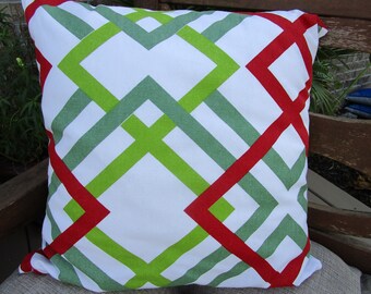 May include: A white pillow with a geometric pattern of red, green, and gray lines. The pillow is made of a soft, comfortable fabric and has a square shape.