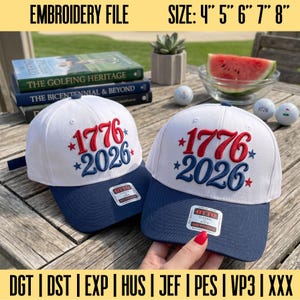 May include: Two white and navy blue baseball caps featuring red embroidered text 1776 and blue embroidered text 2026 with red and blue stars. The caps include Otto Classic stickers on the brims. Text at the top reads EMBROIDERY FILE SIZE: 4" 5" 6" 7" 8".