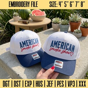 May include: Two white baseball caps with navy blue brims, featuring the embroidered text AMERICAN smoke show and a red heart. The caps include a sticker on the brim and are available in sizes 4, 5, 6, 7, and 8 inches for embroidery files.