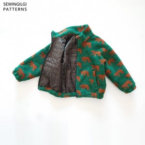 May include: A green and brown bear-patterned fleece jacket with a high collar, long sleeves, and a black zip closure. The interior is lined with a smooth dark brown fabric. The text SEWINGILGI PATTERNS is visible in the top left corner.