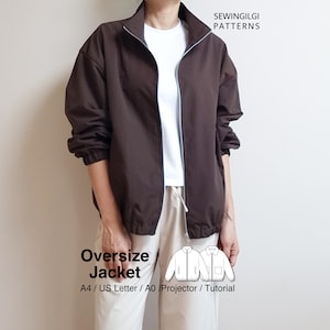 Puede incluir: Chaqueta marrón de gran tamaño con cuello alto y cierre de cremallera. La chaqueta tiene puños elásticos y dobladillo con cordón. El texto "SEWINGILGI PATTERNS" está en la parte superior derecha. El texto "Oversize Jacket" está en la parte inferior izquierda.