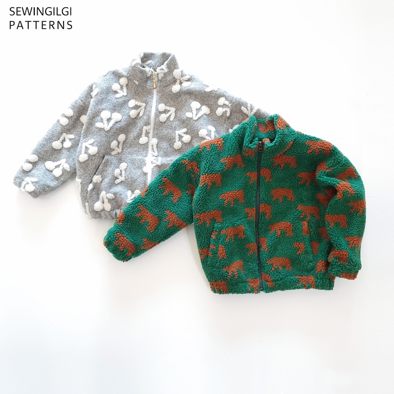 May include: Two zip-up fleece jackets with stand-up collars and front pockets. One jacket is grey with a white cherry pattern, and the other is green with a brown bear pattern. The text SEWINGILGI PATTERNS is visible in the top left corner.