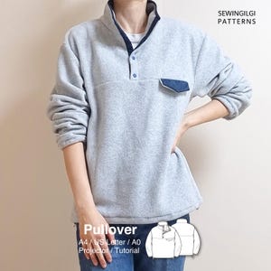 May include: A light grey fleece pullover featuring a dark blue collar trim, a partial button placket, and a single chest pocket with a dark blue flap. The text SEWINGILGI PATTERNS and Pullover A4 / US Letter / A0 Projector / Tutorial are visible.