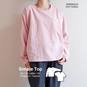 Peut inclure: Un haut rose clair à manches longues avec une poche unique sur la poitrine. L'image présente un patron de couture intitulé "Simple Top" et "Sewingilgi Patterns". Le haut est porté avec un pantalon bleu foncé.