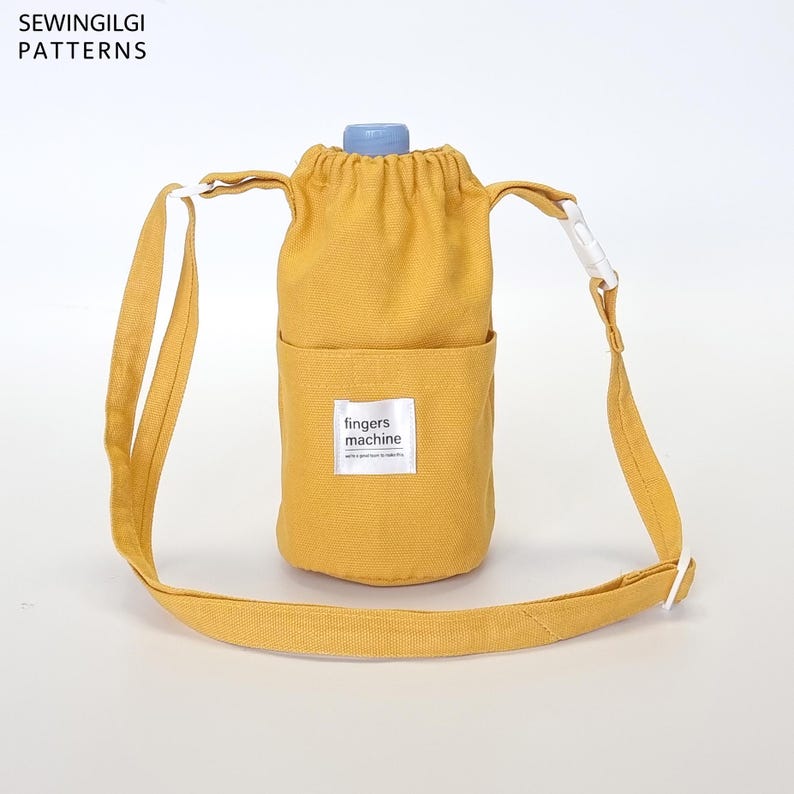 May include: A mustard yellow canvas water bottle carrier with an adjustable strap and a small pocket that says "fingers machine".