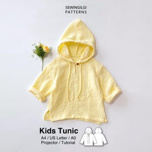 May include: A light yellow hooded tunic with a textured fabric, short sleeves, and a single button at the neckline. The text SEWINGILGI PATTERNS, Kids Tunic, A4 / US Letter / A0 Projector / Tutorial is visible along with a line drawing of the garment.