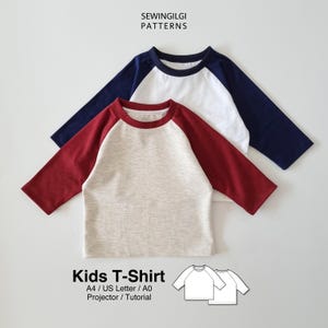 Könnte beinhalten: Zwei Kinder-Raglan-T-Shirts. Eines ist weiß mit marineblauen Ärmeln, das andere ist beige mit bordeauxroten Ärmeln. Der Text "SEWINGILGI PATTERNS" steht oben. Der Text "Kids T-Shirt" steht unten, zusammen mit den Musterdetails.