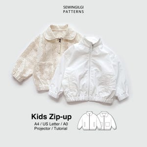 Op de afbeelding: Twee kinderzipjacks, één crème met een kantpatroon, de andere wit. Beide hebben voorzakken en ritssluitingen. De tekst luidt "SEWINGILGI PATTERNS" en "Kids Zip-up".