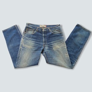 May include: A pair of blue denim jeans with a faded look. The jeans have a classic five-pocket style and a straight leg.