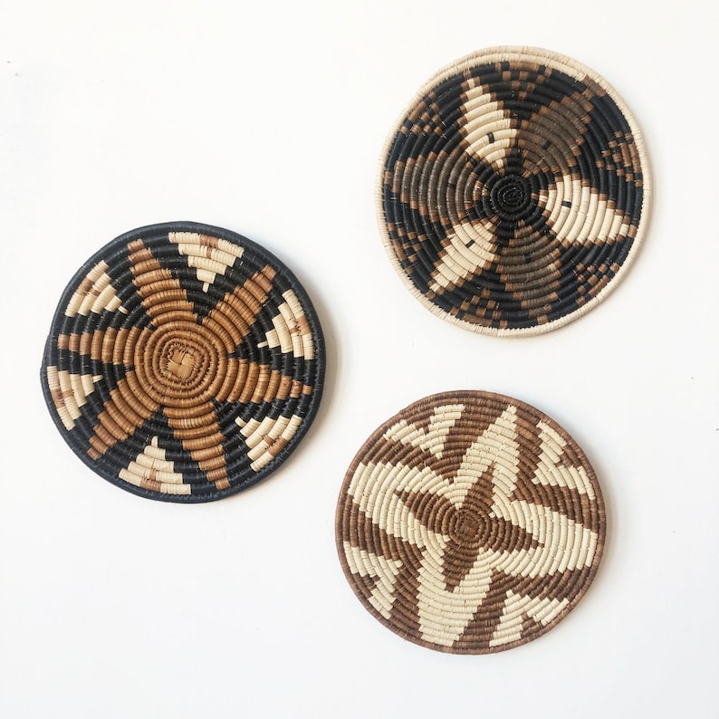 May include: Three round woven wall decor pieces with geometric patterns in black, brown, and white.