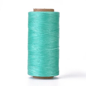 May include: A spool of turquoise waxed thread for leather crafting.