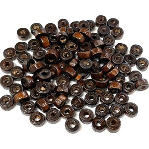 May include: A large pile of brown wooden beads. The beads are round and have a hole in the center. They are perfect for crafting projects.