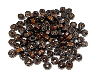 May include: A large pile of brown wooden beads. The beads are round and have a hole in the center. They are perfect for crafting projects.