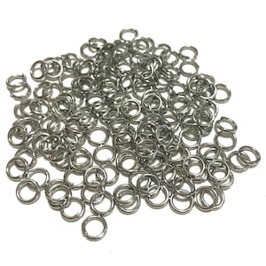 May include: A large pile of silver jump rings. The rings are small and round, and they are all linked together.