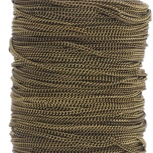 May include: A spool of antique gold chain, perfect for jewelry making or crafting projects. The chain is tightly wound and has a slightly textured finish.